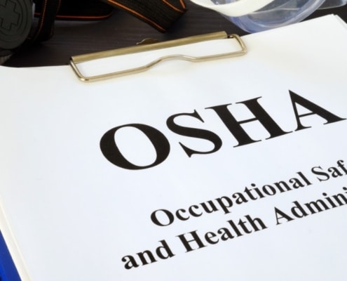 A close-up of a white paper attached to a clipboard that reads "OSHA" and "Occupational Safety and Health Administration."