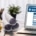 A laptop that displays an online health insurance form on its screen next to a hard hat and construction supplies.
