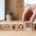 A close-up of a set of wooden blocks with various icons, with a hand pulling out one that reads "SAFETY FIRST."