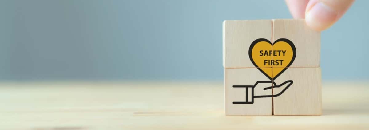 Four wooden locks stacked together to form a box with a graphic of a hand below a yellow heart that reads "SAFETY FIRST."